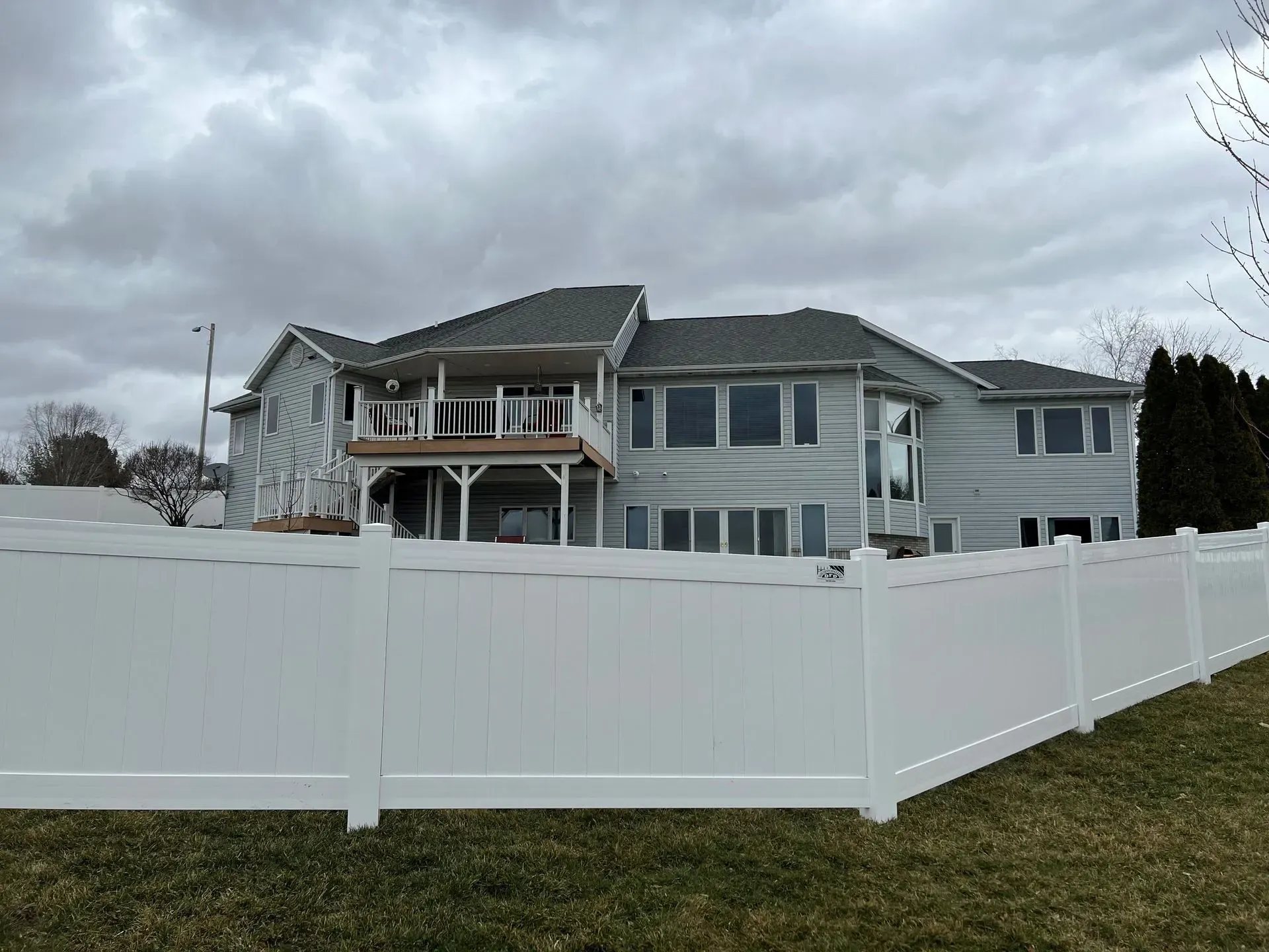 A large house with a white fence in front of it.