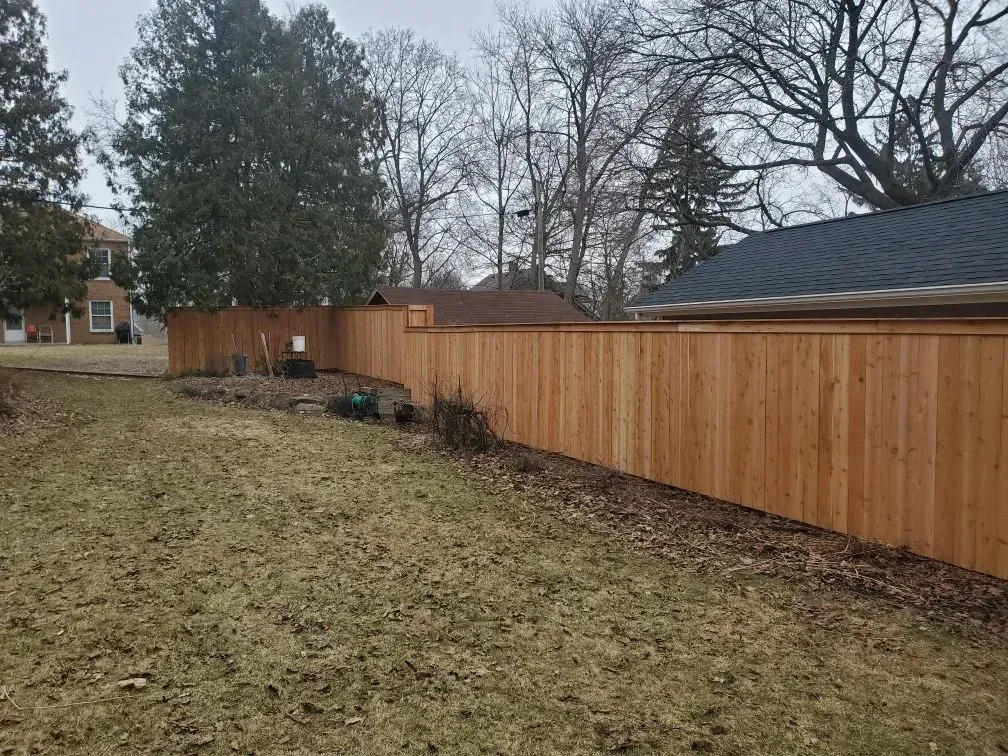 There is a wooden fence in the backyard of a house.