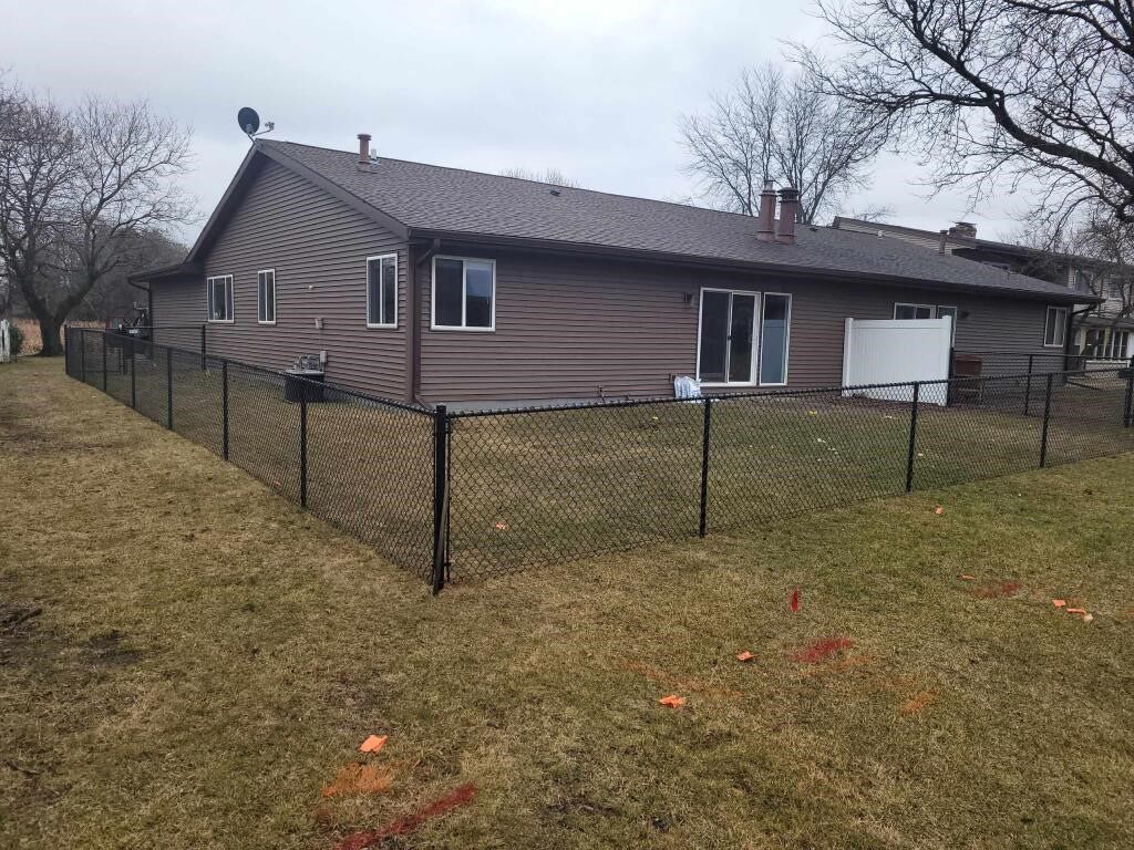 A house with a chain link fence in front of it.