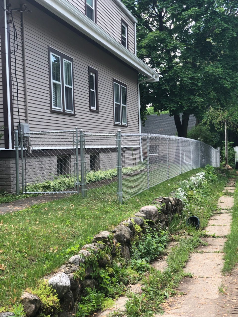 There is a chain link fence in front of a house.