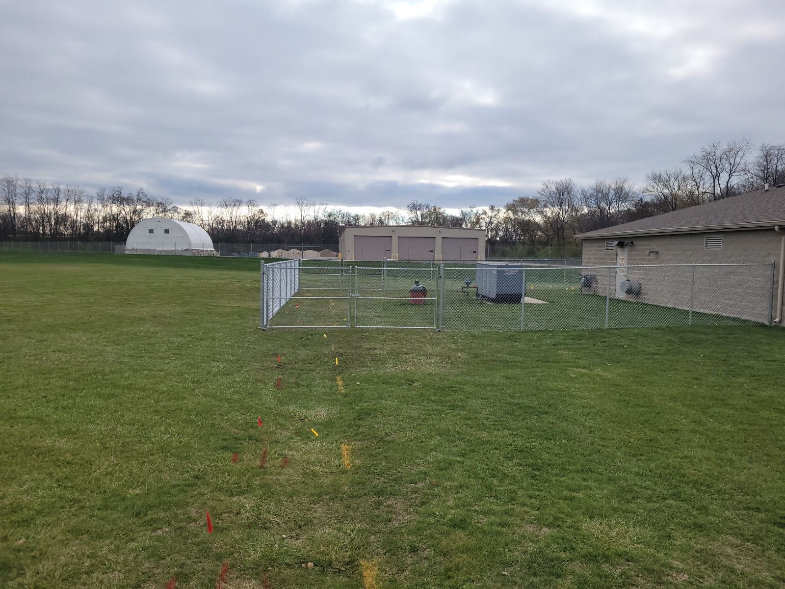 A fenced in yard with a house in the background