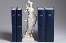 A mini sculpture of lady justice with books for law