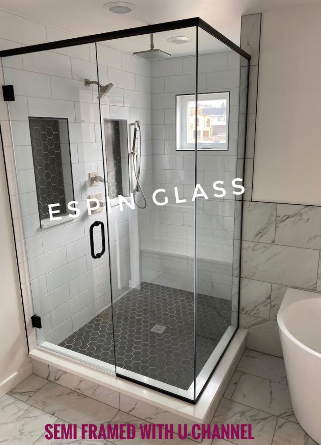 Corner shower with black frame, glass doors, white and black tile, and a built-in bench.