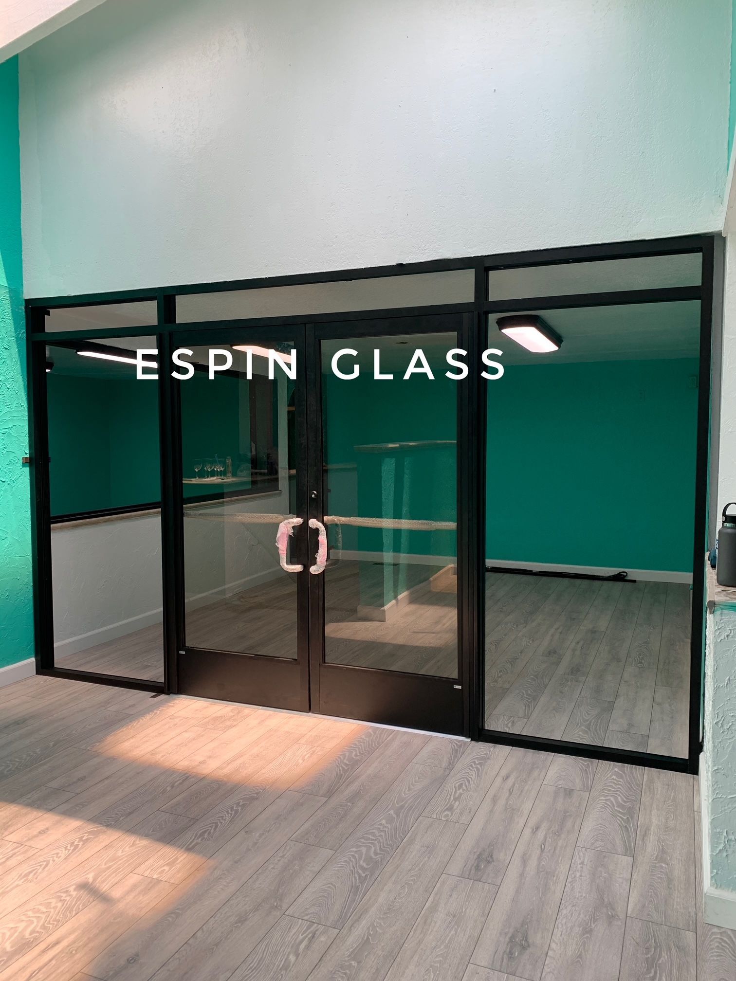 Glass door entrance with black frame, white lettering 