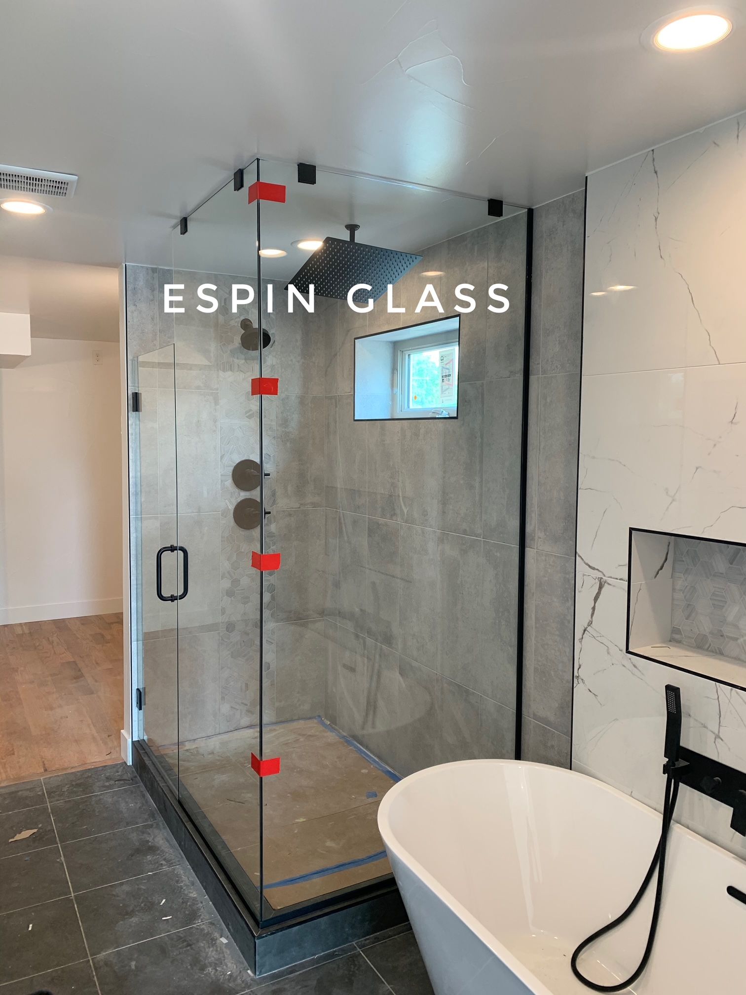 Modern bathroom with glass shower enclosure and freestanding tub.