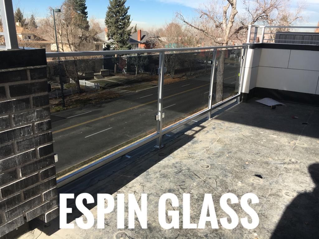 Glass railing on a rooftop overlooking a street. 