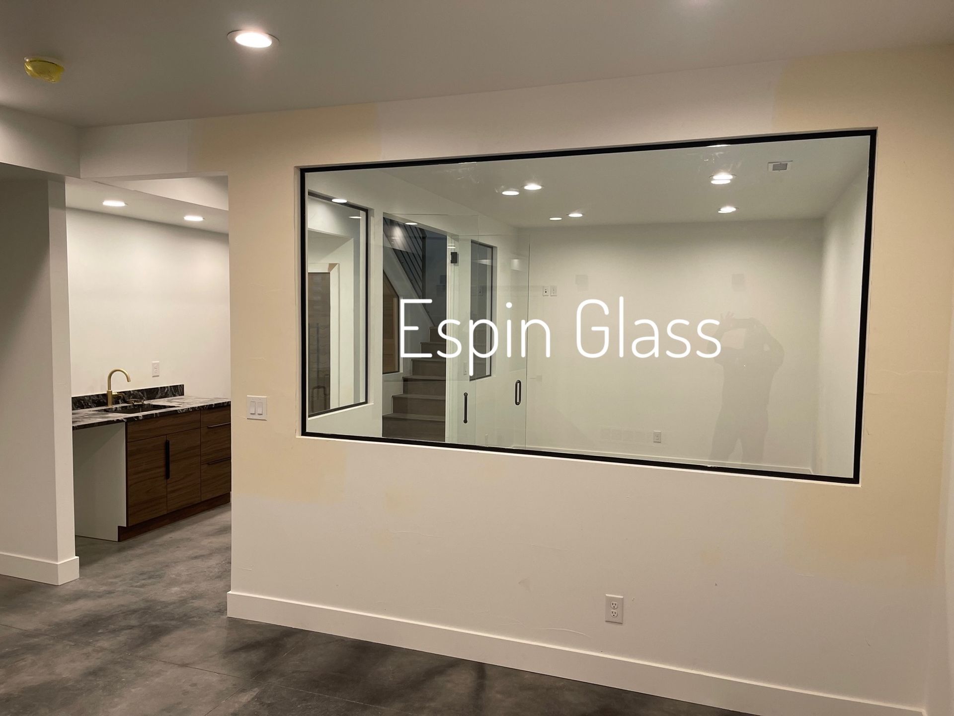 Interior view with large mirror framed in black. Reveals another room with a staircase, with 