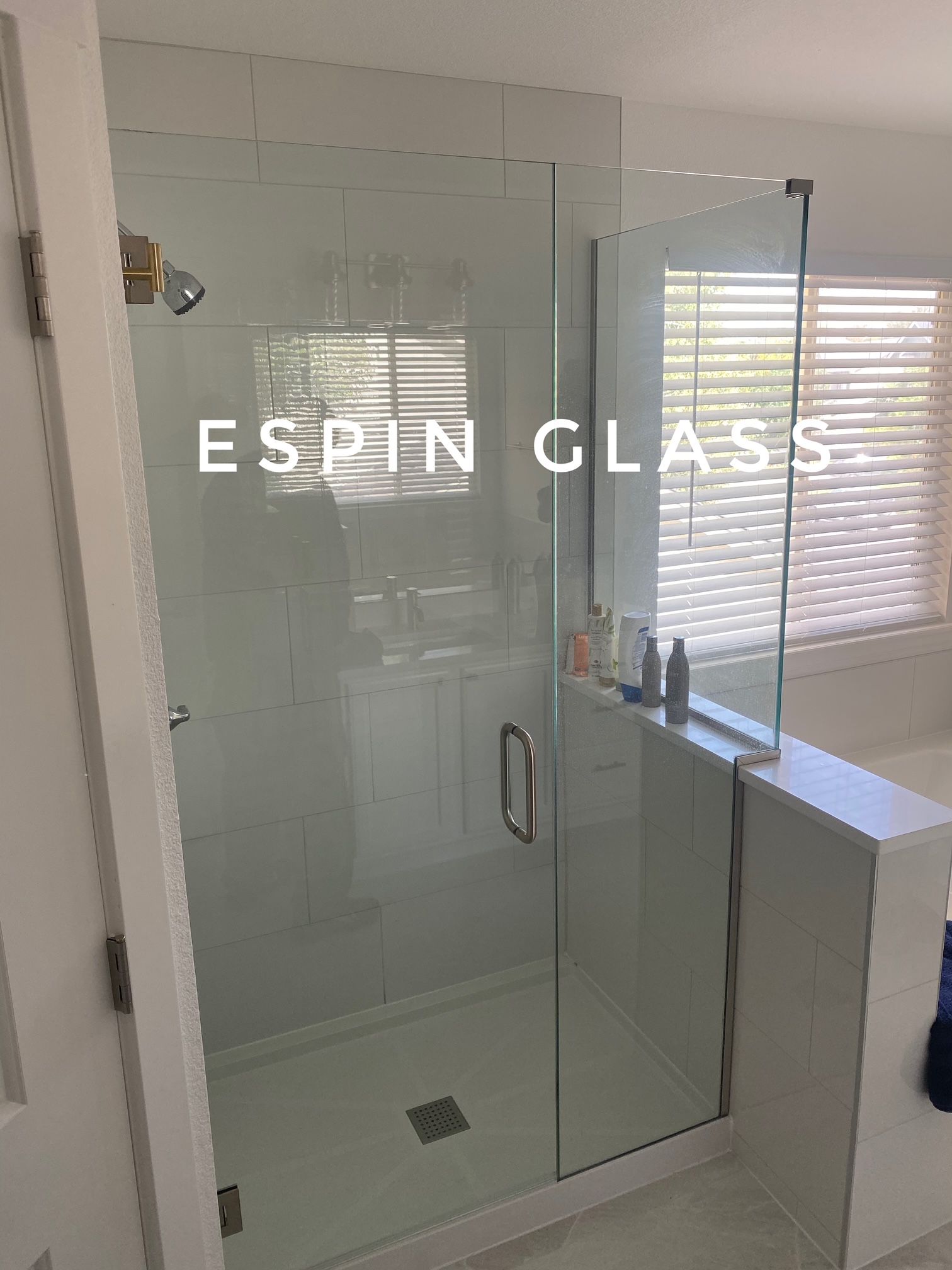 Glass shower enclosure in a white bathroom.