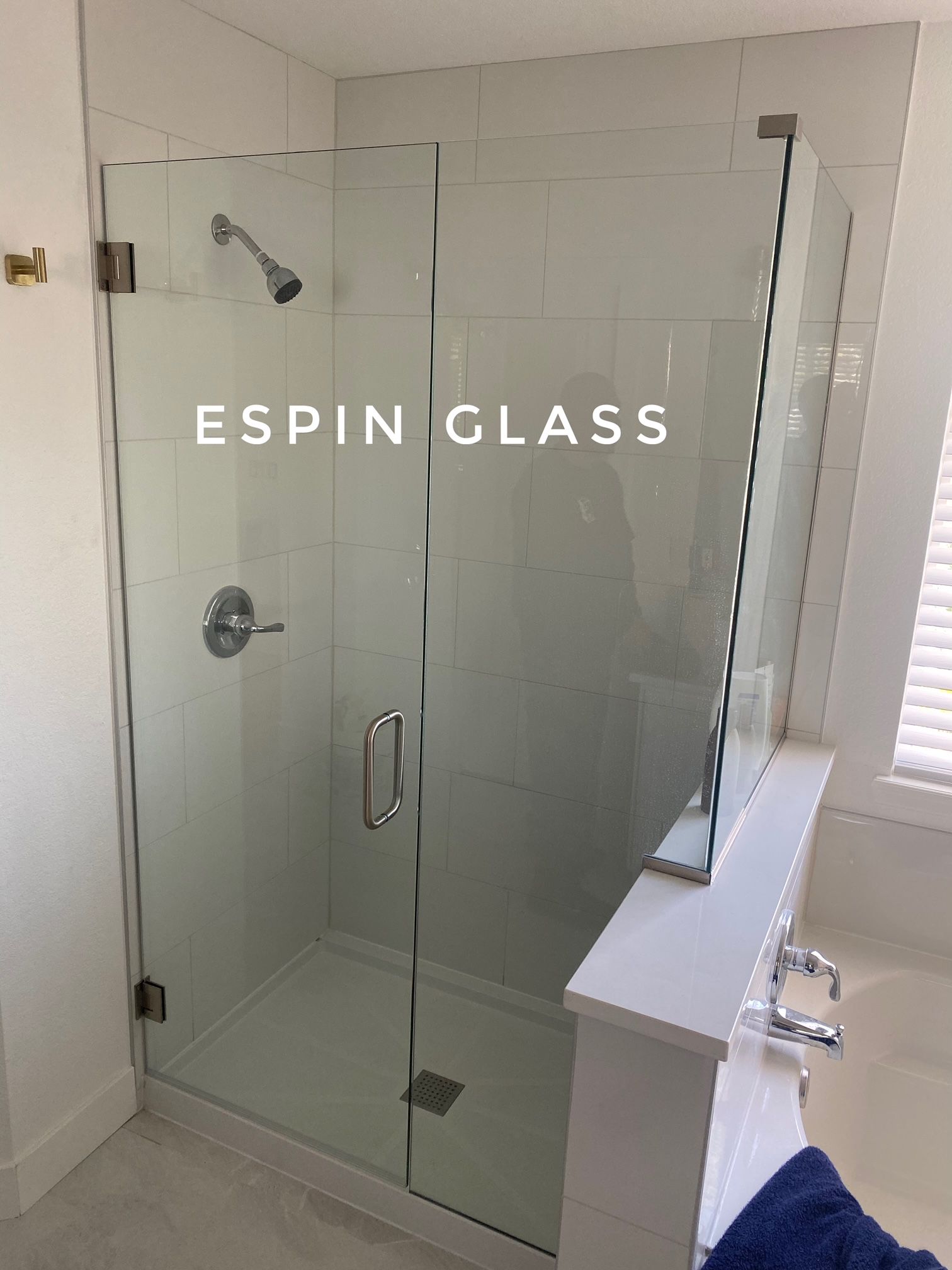 Frameless glass shower enclosure with chrome fixtures.