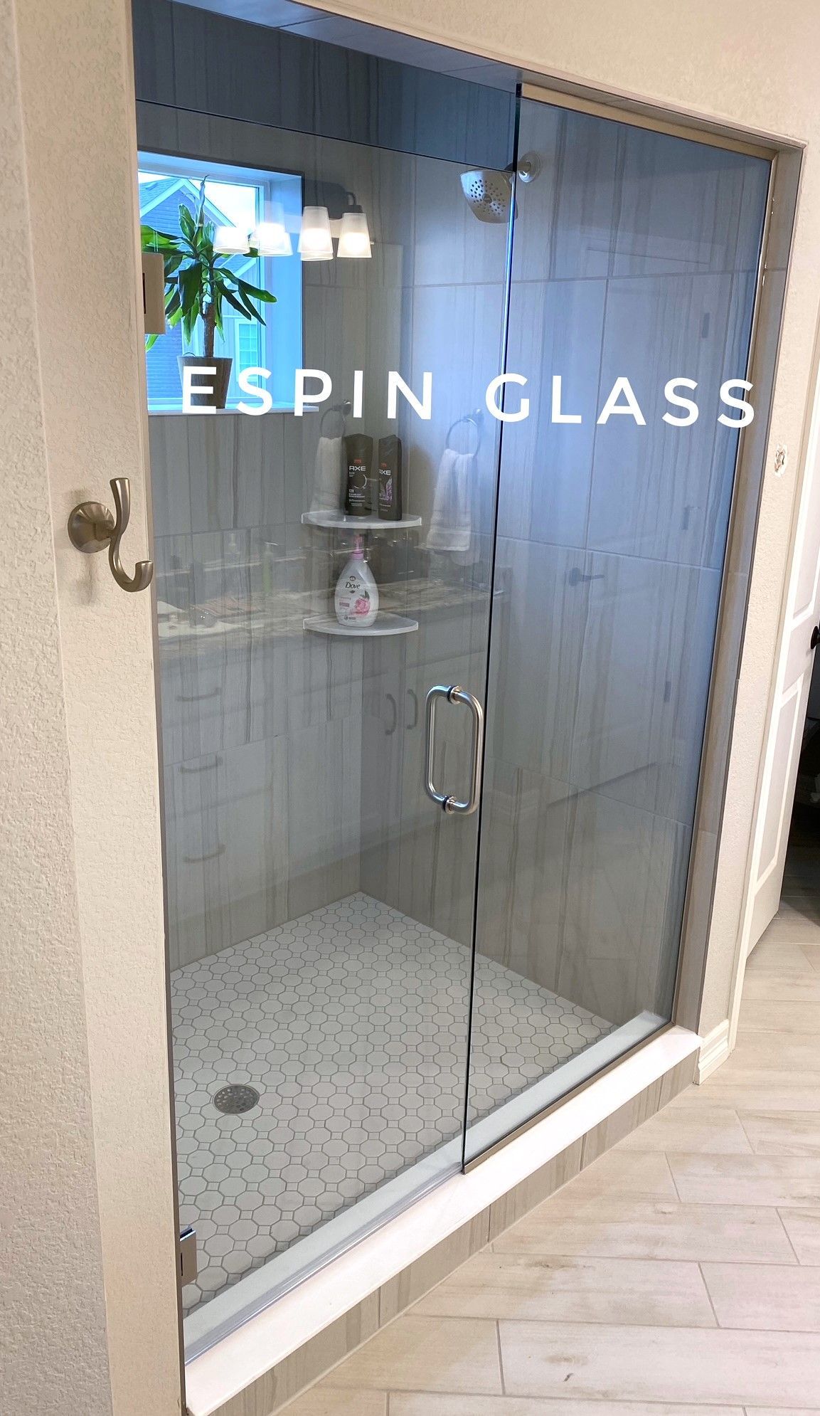 Glass shower with gray tile, a clear door, and 