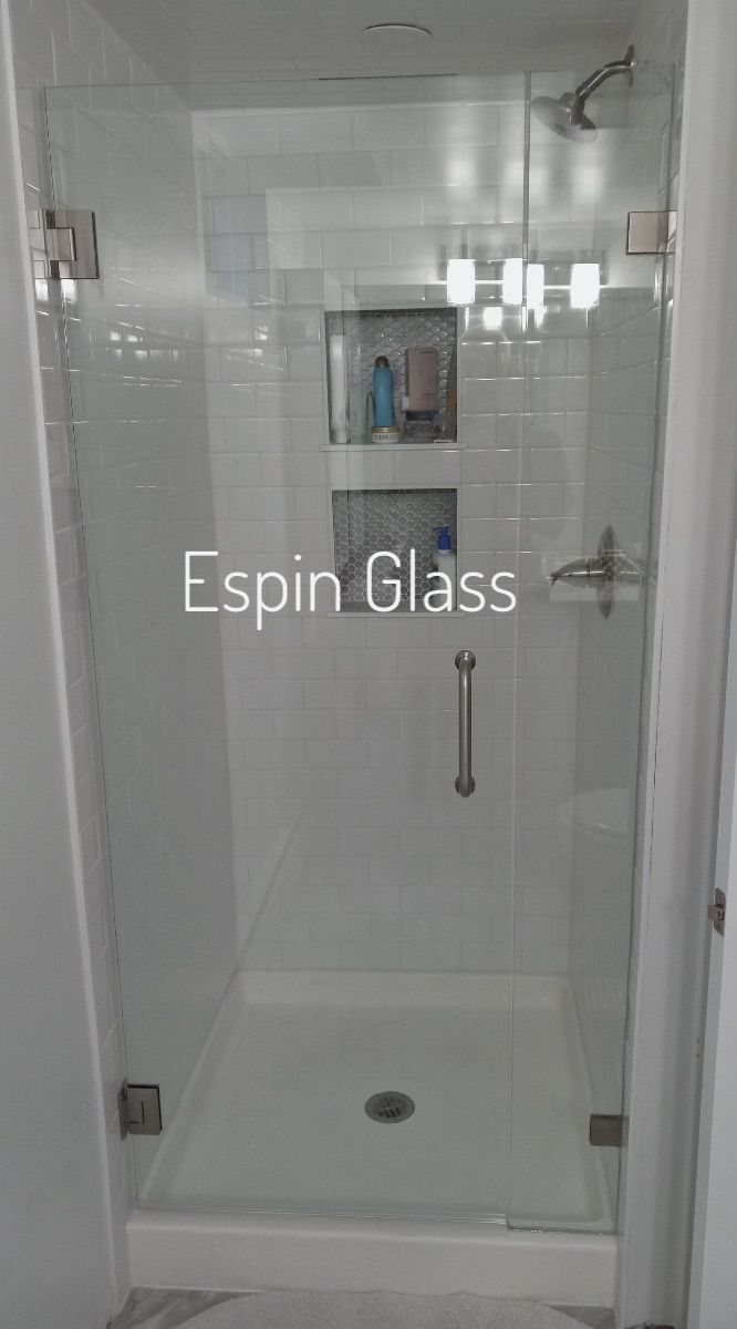 Clear glass shower enclosure in a white bathroom.