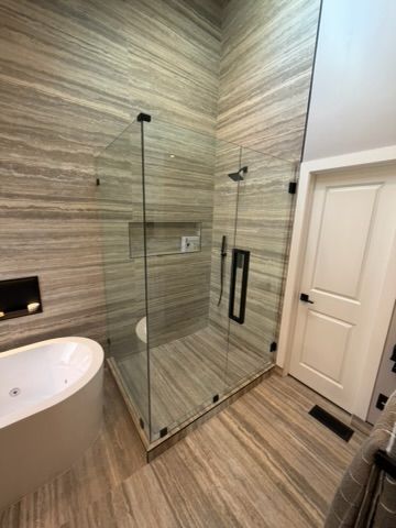 Modern bathroom with glass walk-in shower, wood-look tile walls and floor, and a white vanity.