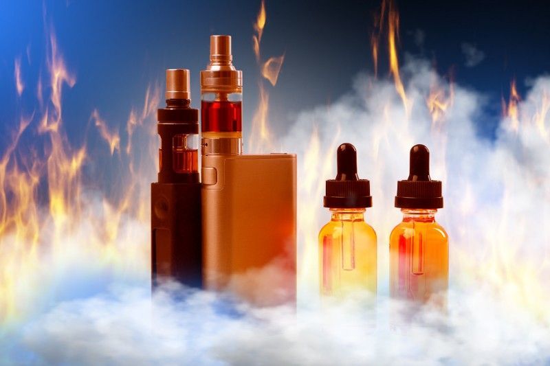 A group of e-cigarettes sitting next to each other in front of a fire.