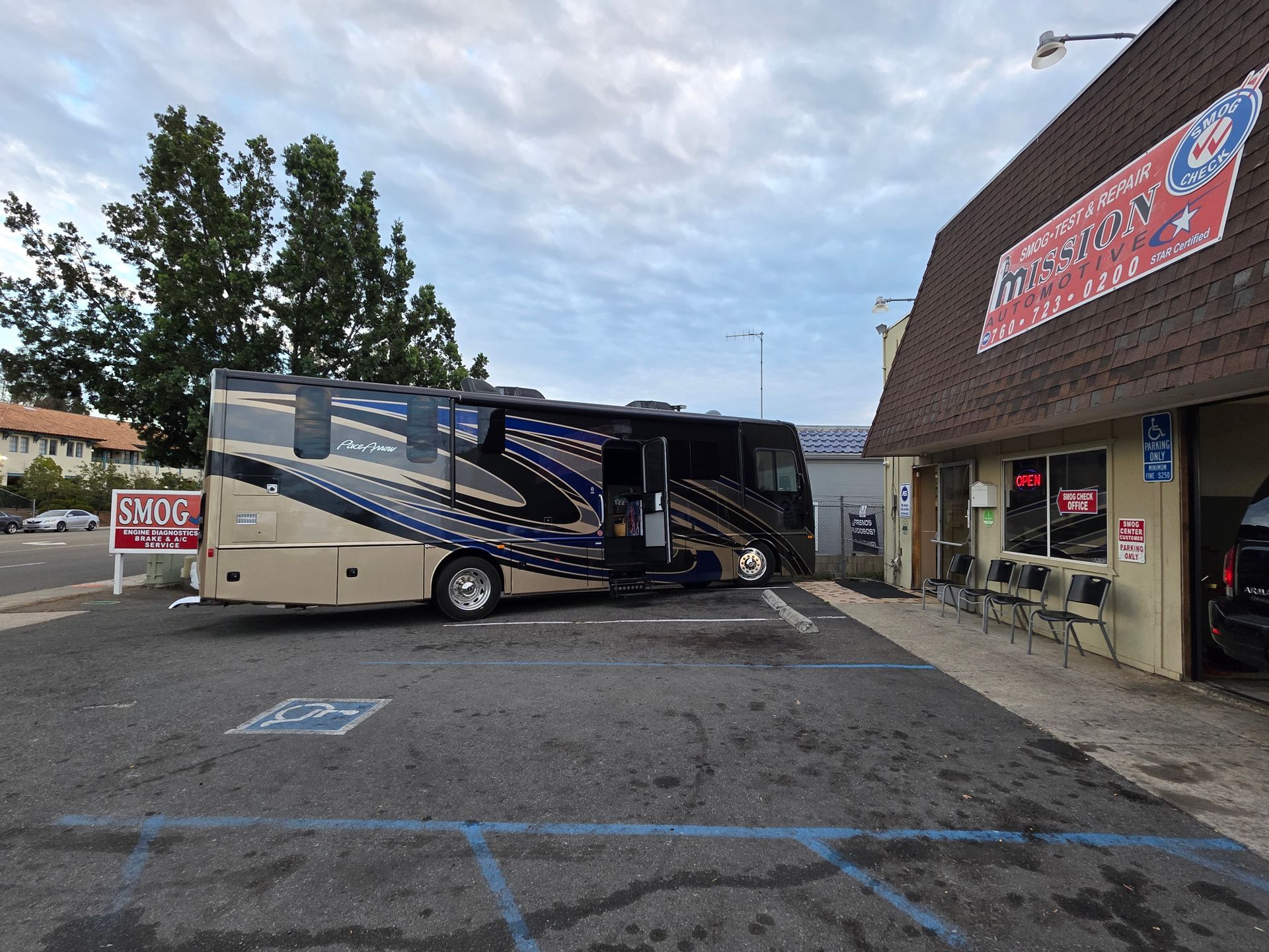 Motorhome parked outside a building with blue accessible parking lines on the pavement