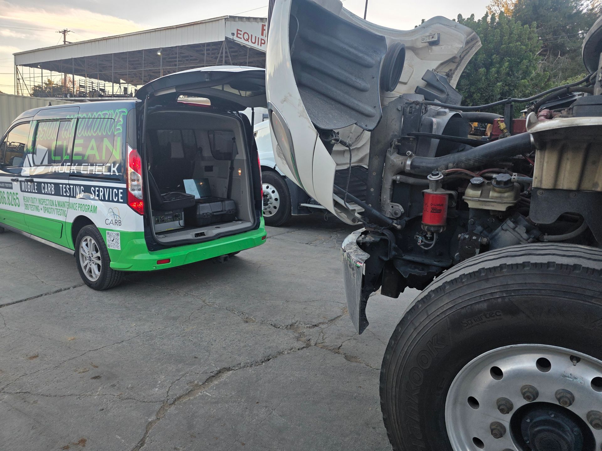 Damaged minibus and truck after a road collision, with debris on the street and a green van nearby