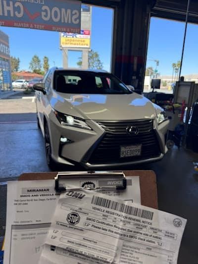 Silver Lexus SUV in a service bay, viewed behind a clipboard and paperwork in the foreground