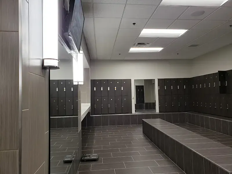 a locker room with lots of lockers and a mirror