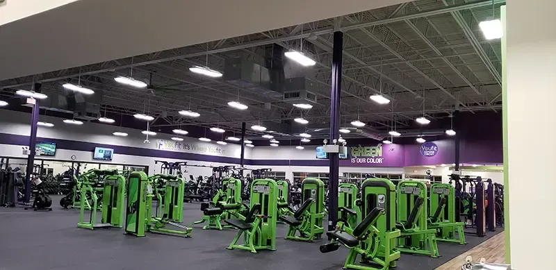 a gym filled with green and purple exercise equipment
