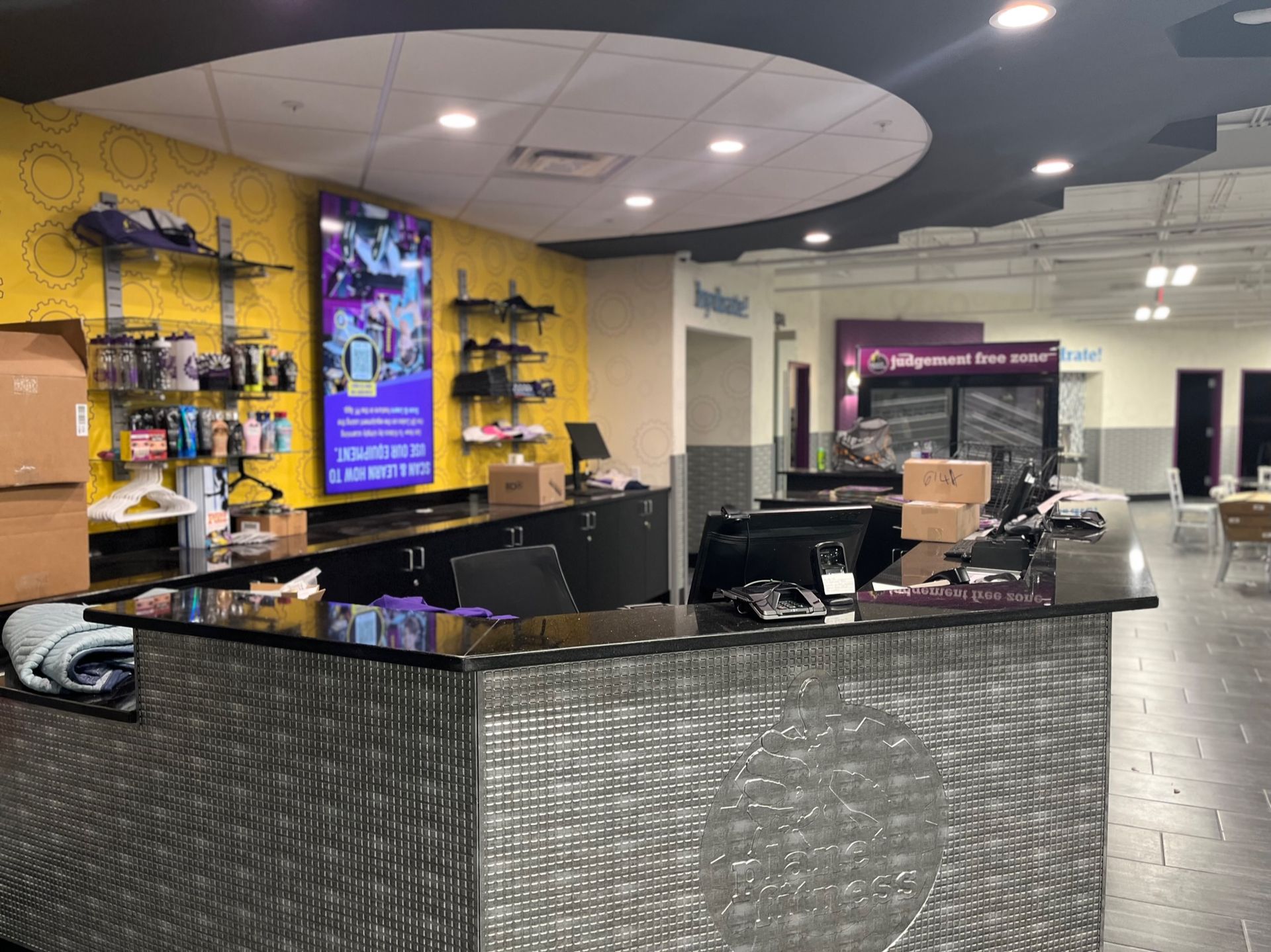 Salon reception desk with product displays, mirrors, and a black counter under bright ceiling lights