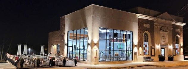 a large building with a lot of windows is lit up at night