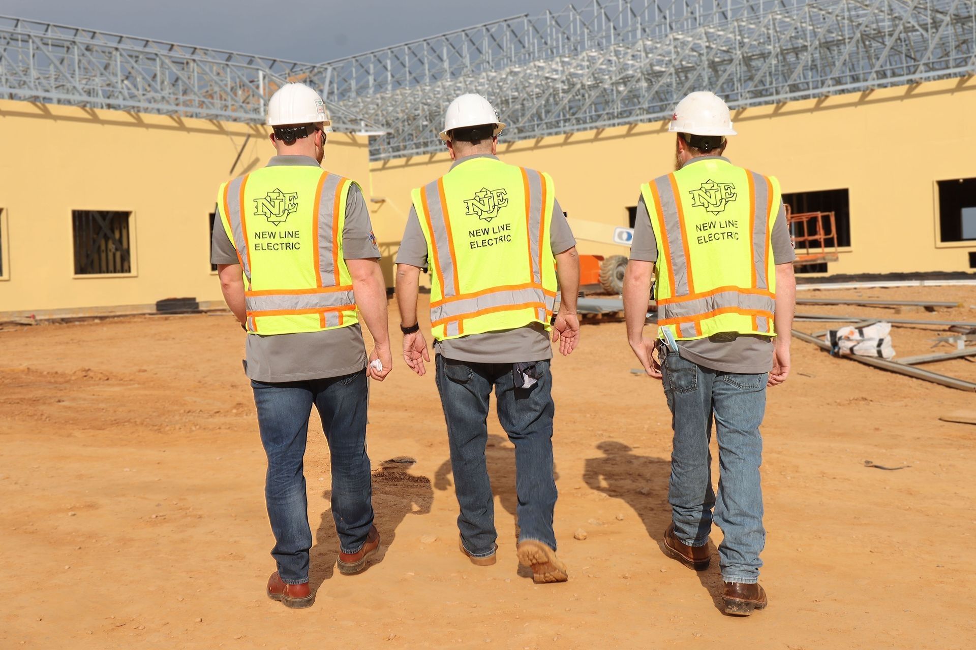 three construction workers wearing hard hats and safety vests