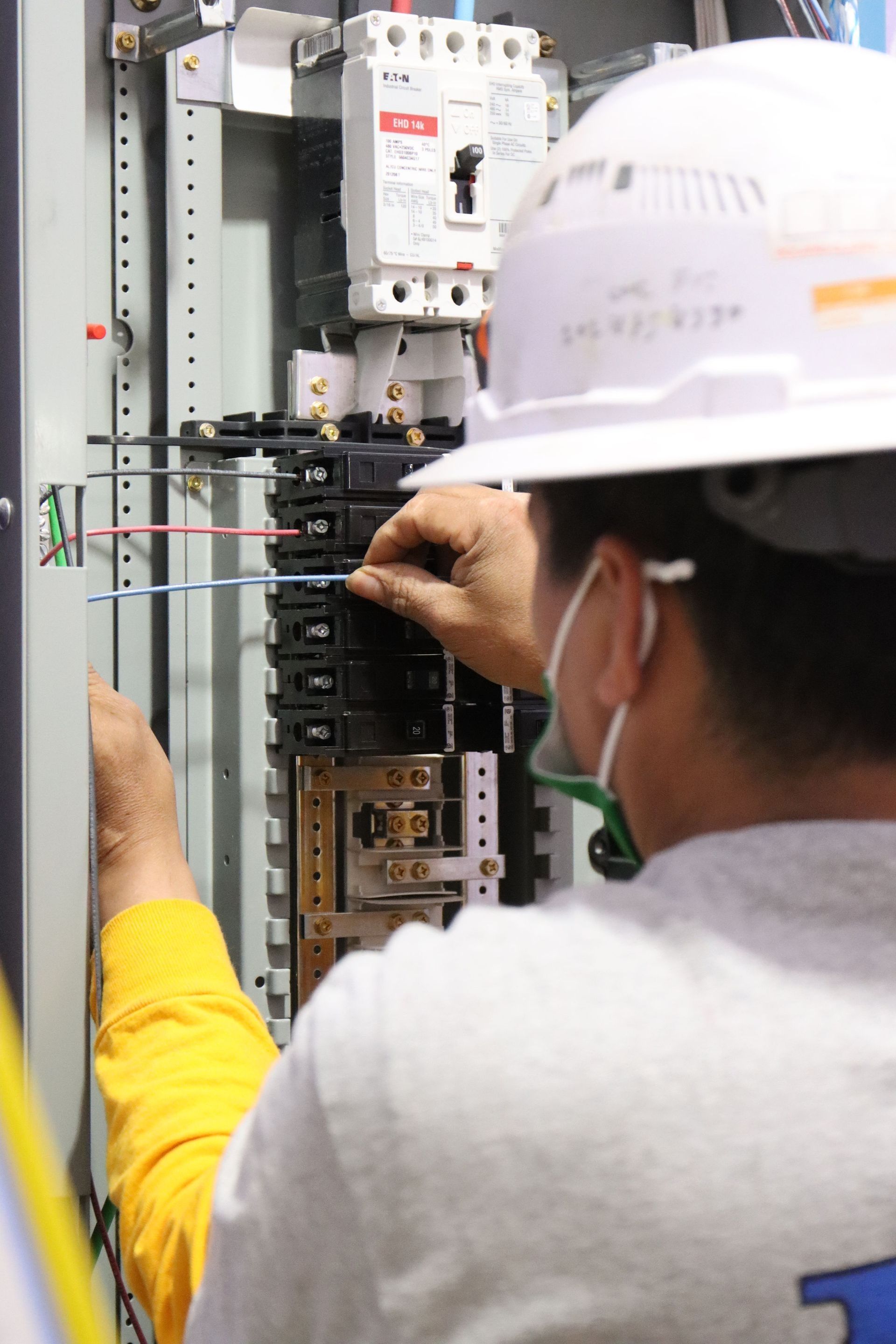 a man wearing a hard hat is working on an electrical box
