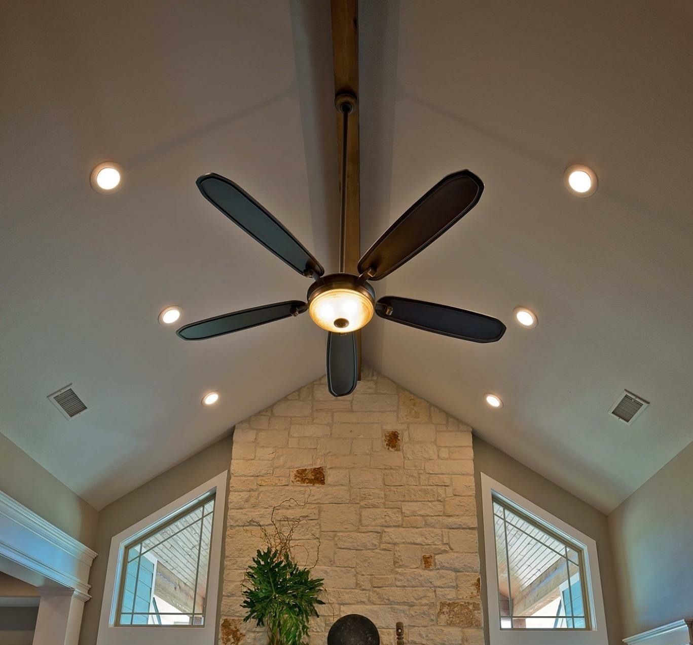 A ceiling fan is hanging from the ceiling above a fireplace