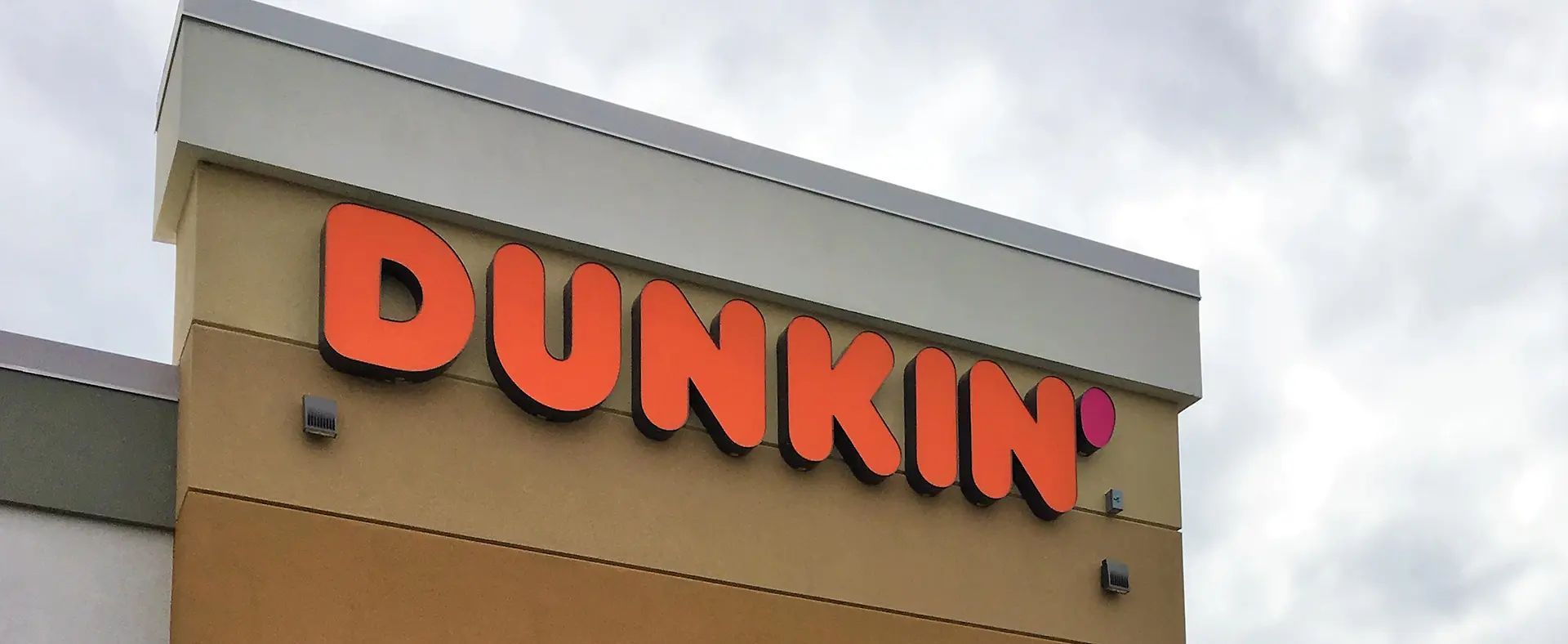 a dunkin' donuts sign on the side of a building