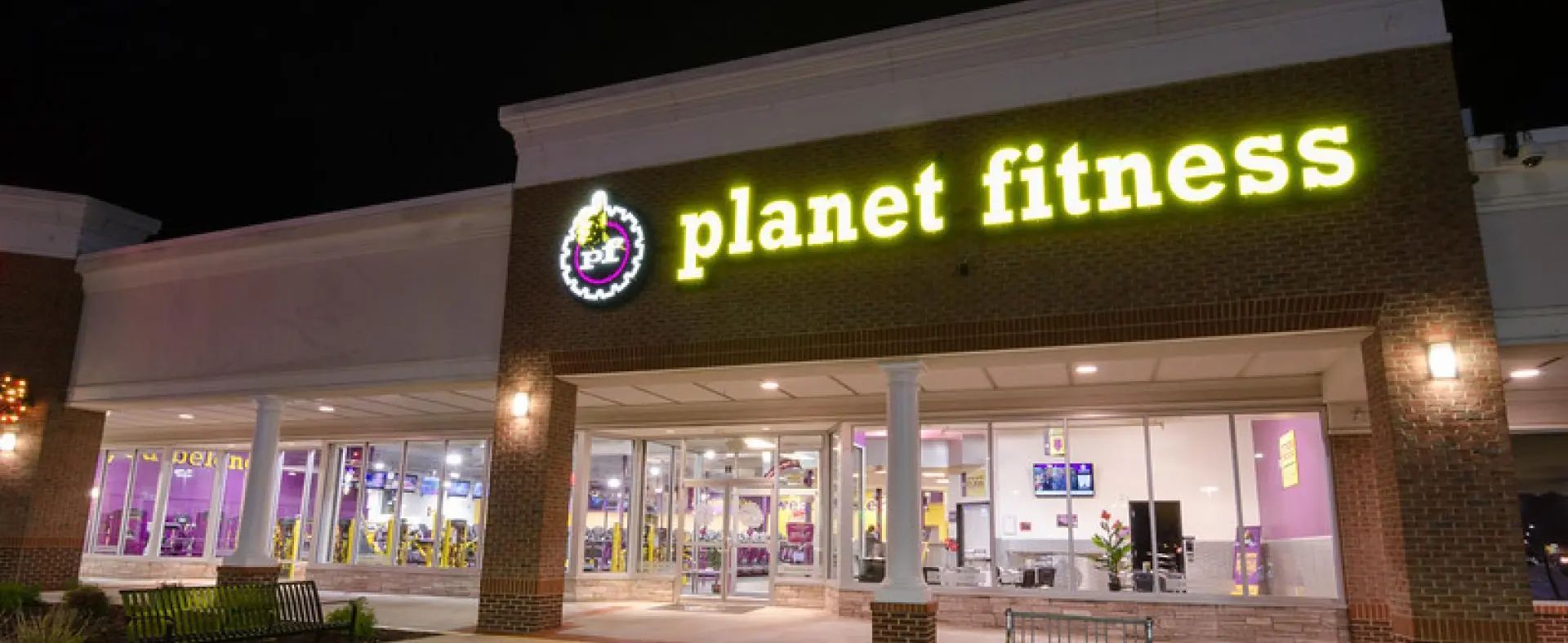 a planet fitness gym is lit up at night
