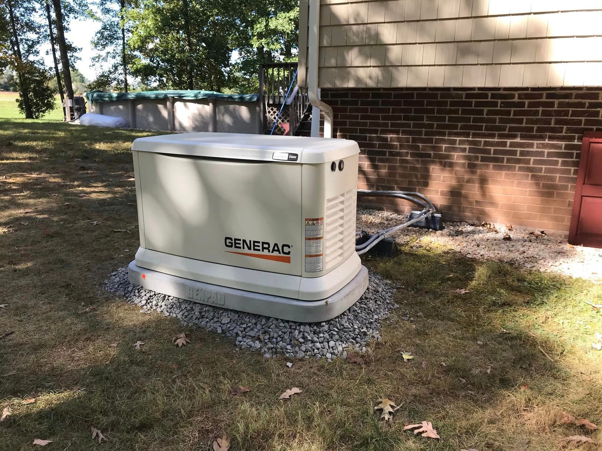 A generator is sitting in the grass in front of a house