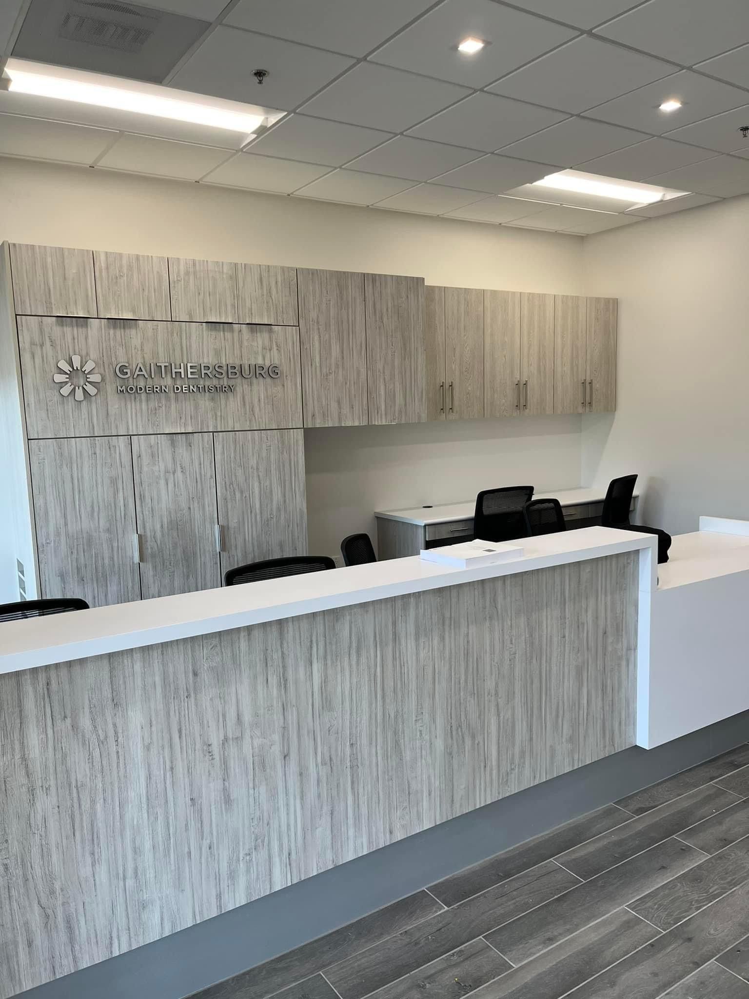 a reception area in a hospital with a wooden counter and cabinets
