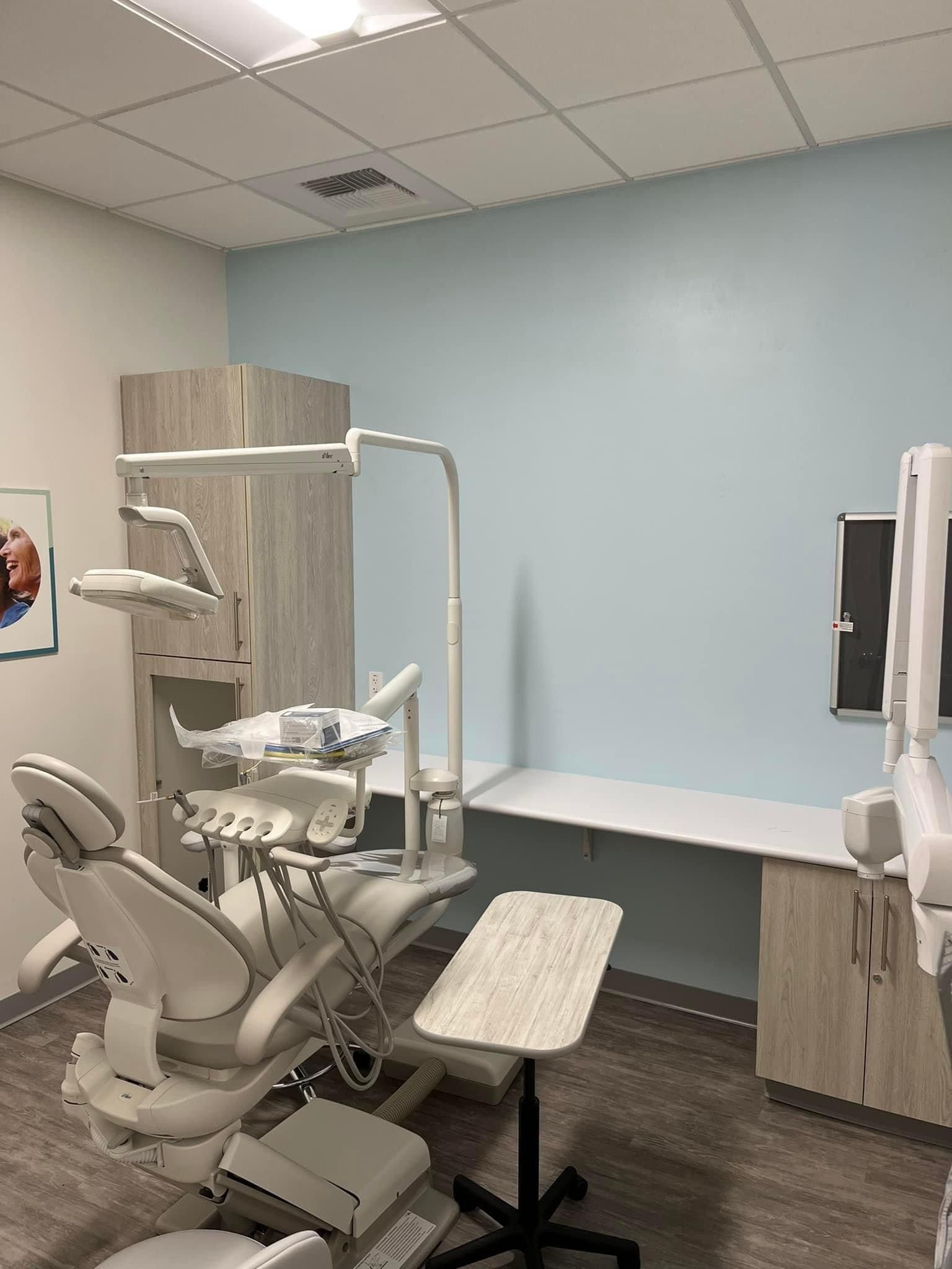 a dental office with a dental chair and a desk