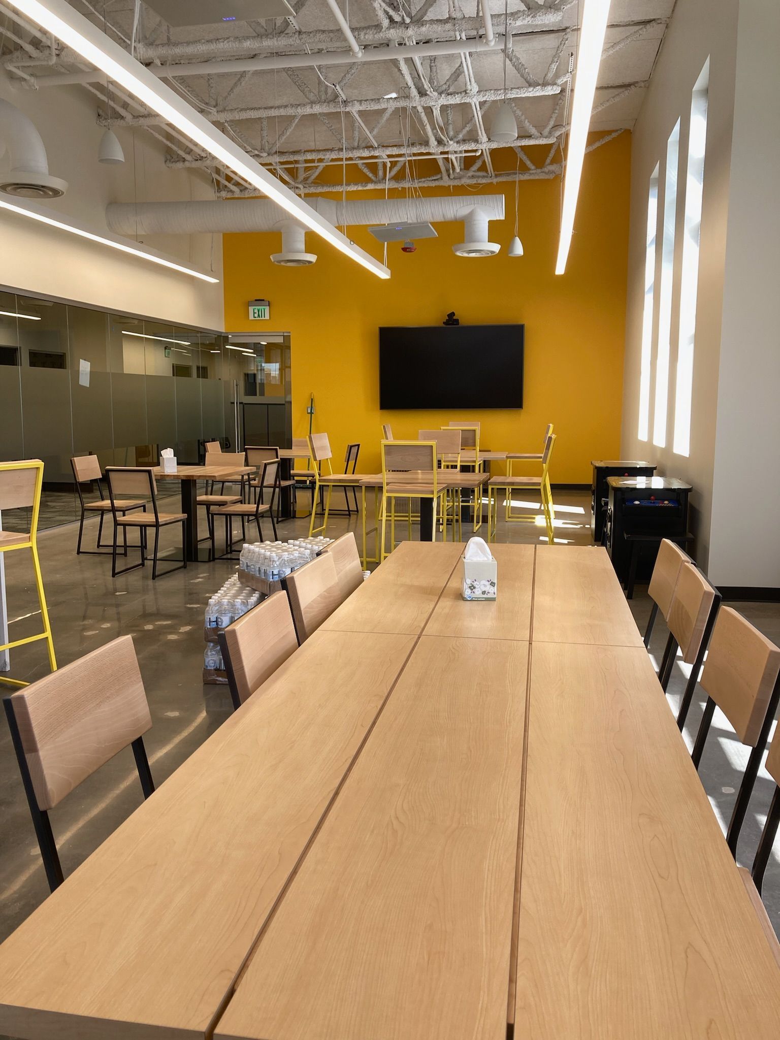 a large room with tables and chairs and a yellow wall