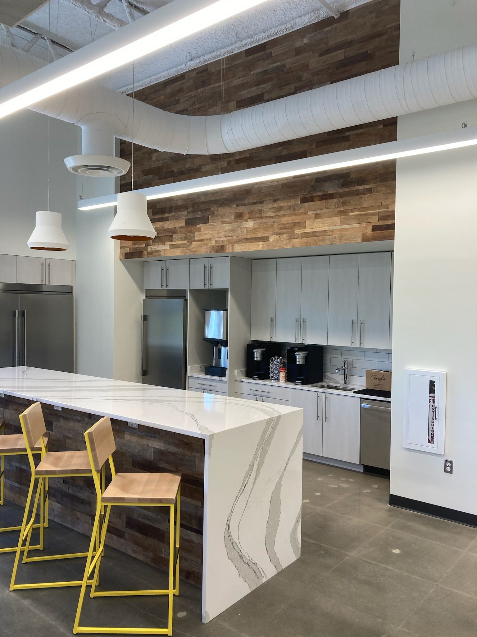a kitchen with a long counter and yellow stools