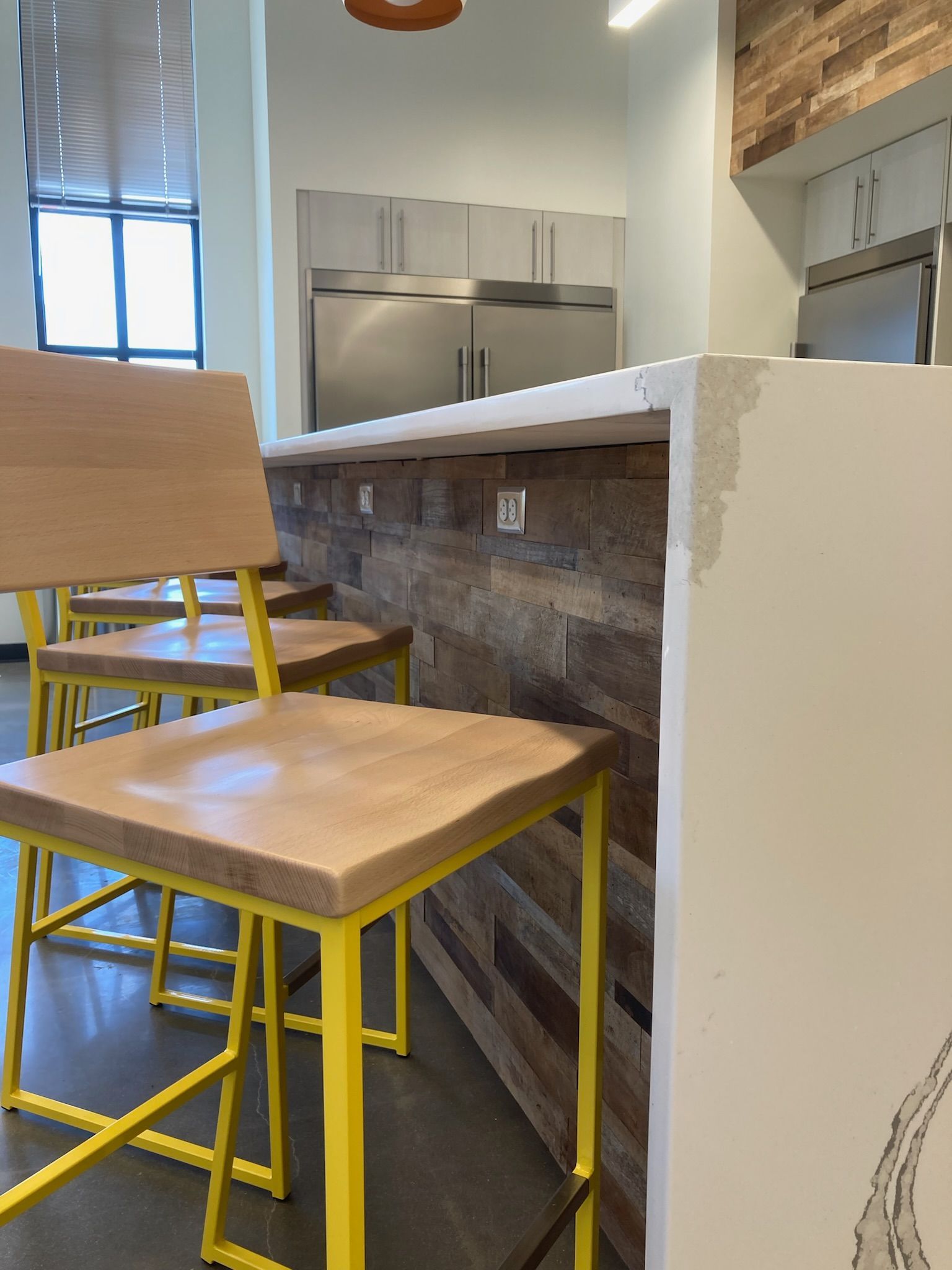 a kitchen with wooden chairs and yellow legs