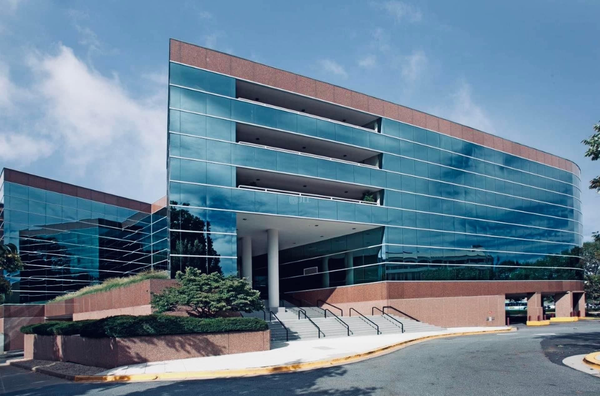 a large glass building with stairs leading up to it