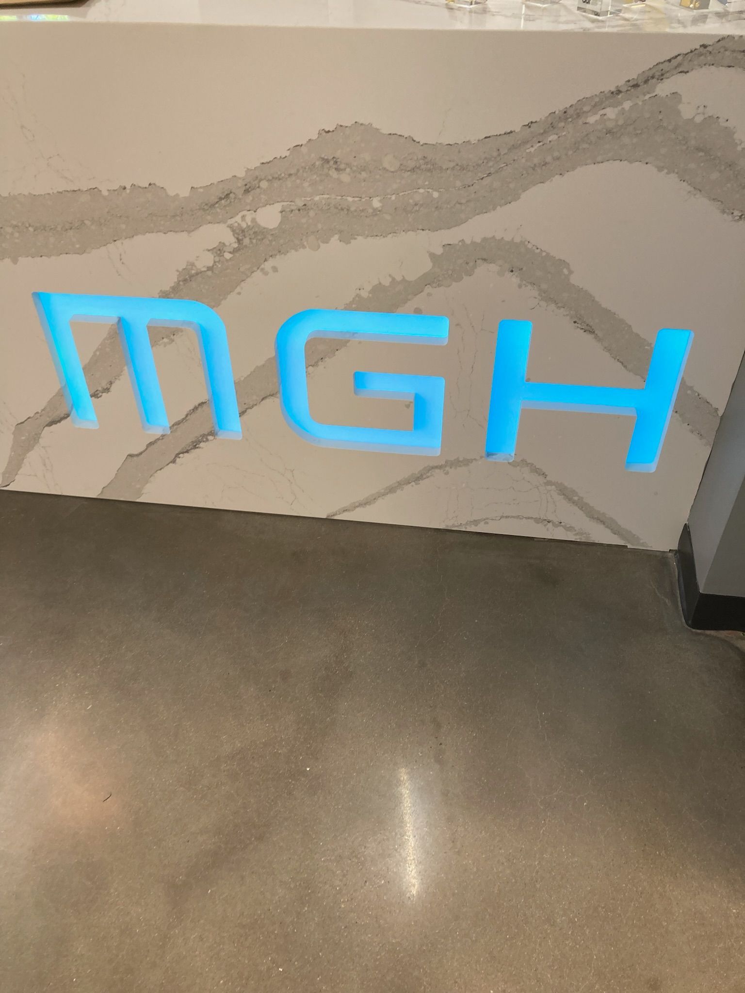 a sign that says MGH in blue letters on a counter