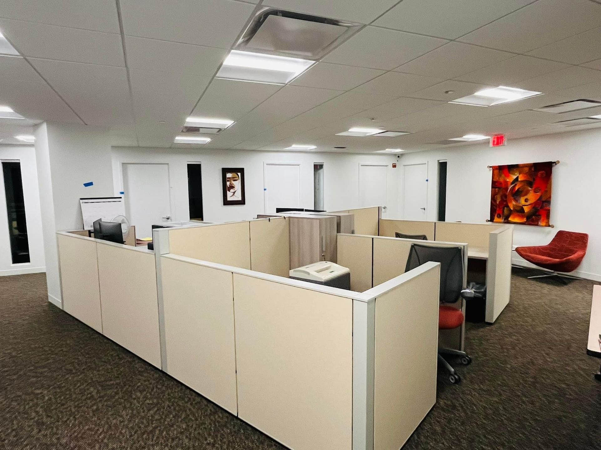 a large office with cubicles and a red chair