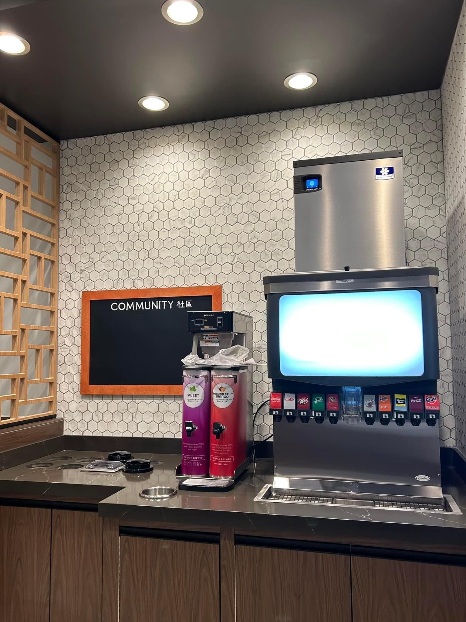 a kitchen with a soda machine and a chalkboard on the wall