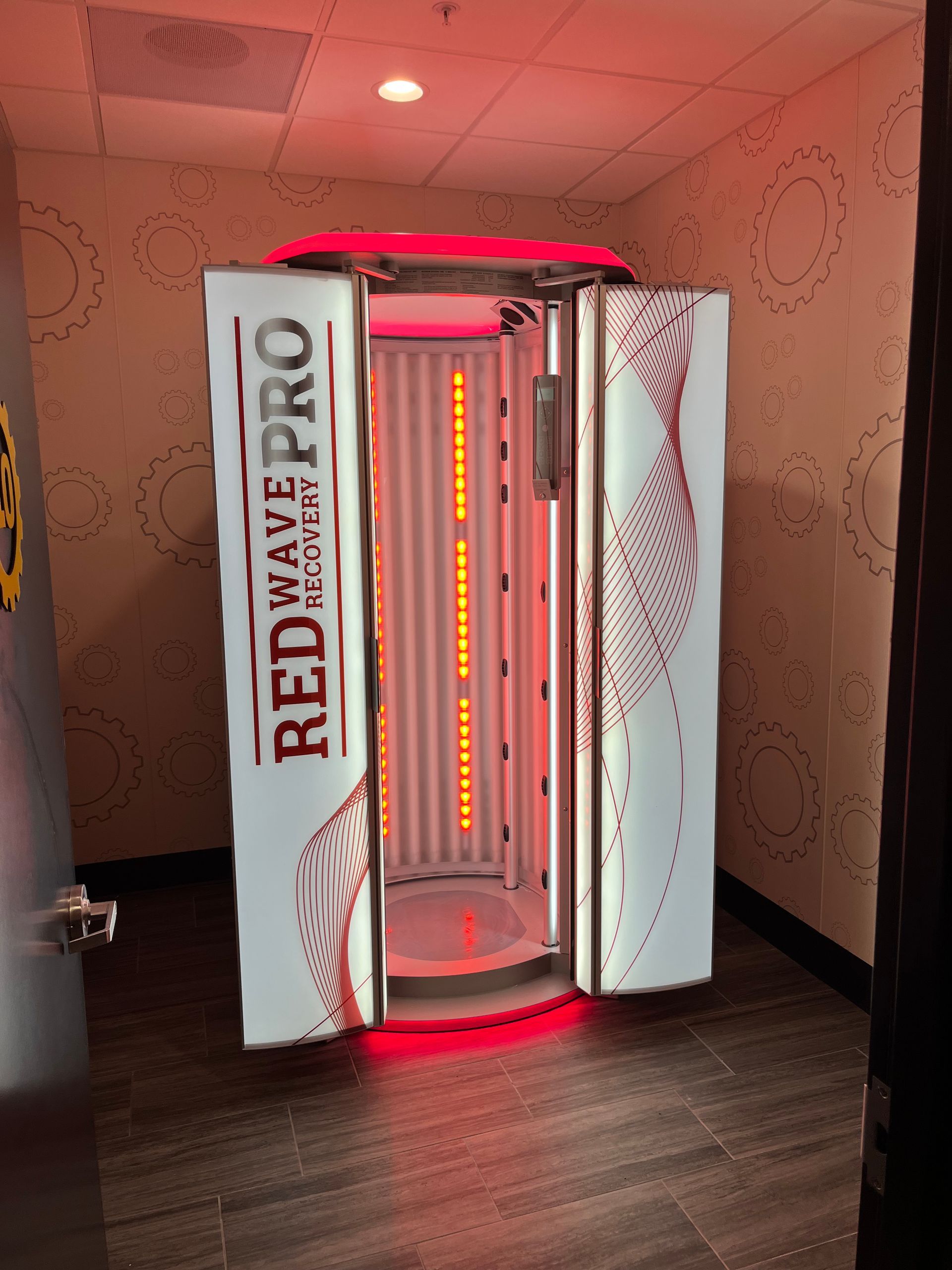 Red-Way Pro red light therapy booth with glowing red interior in a spa room