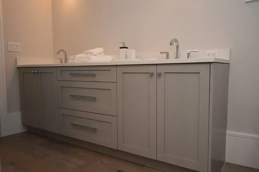 Light gray double bathroom vanity with white countertop and silver hardware.