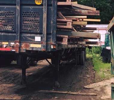 A truck with a stack of wood on the back of it.