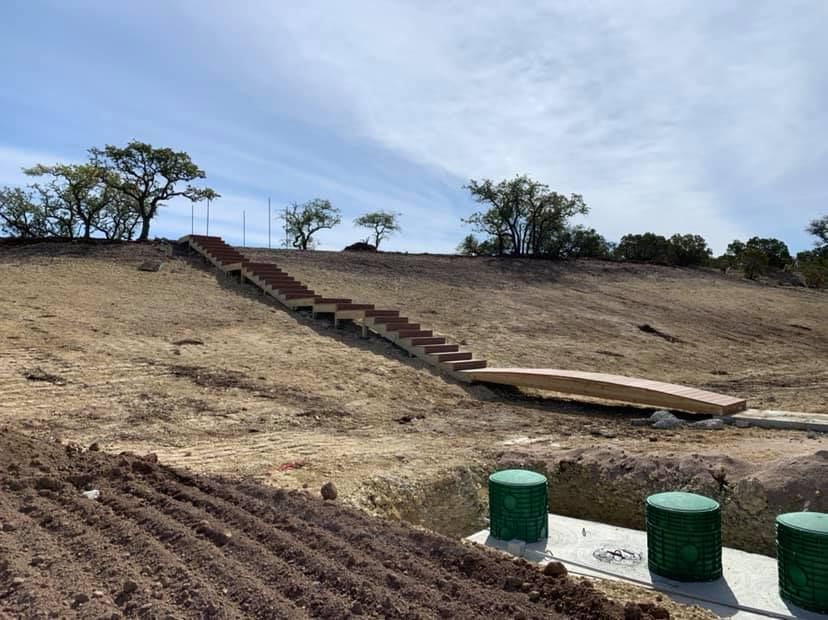 A group of stairs going up a hill in a dirt field.