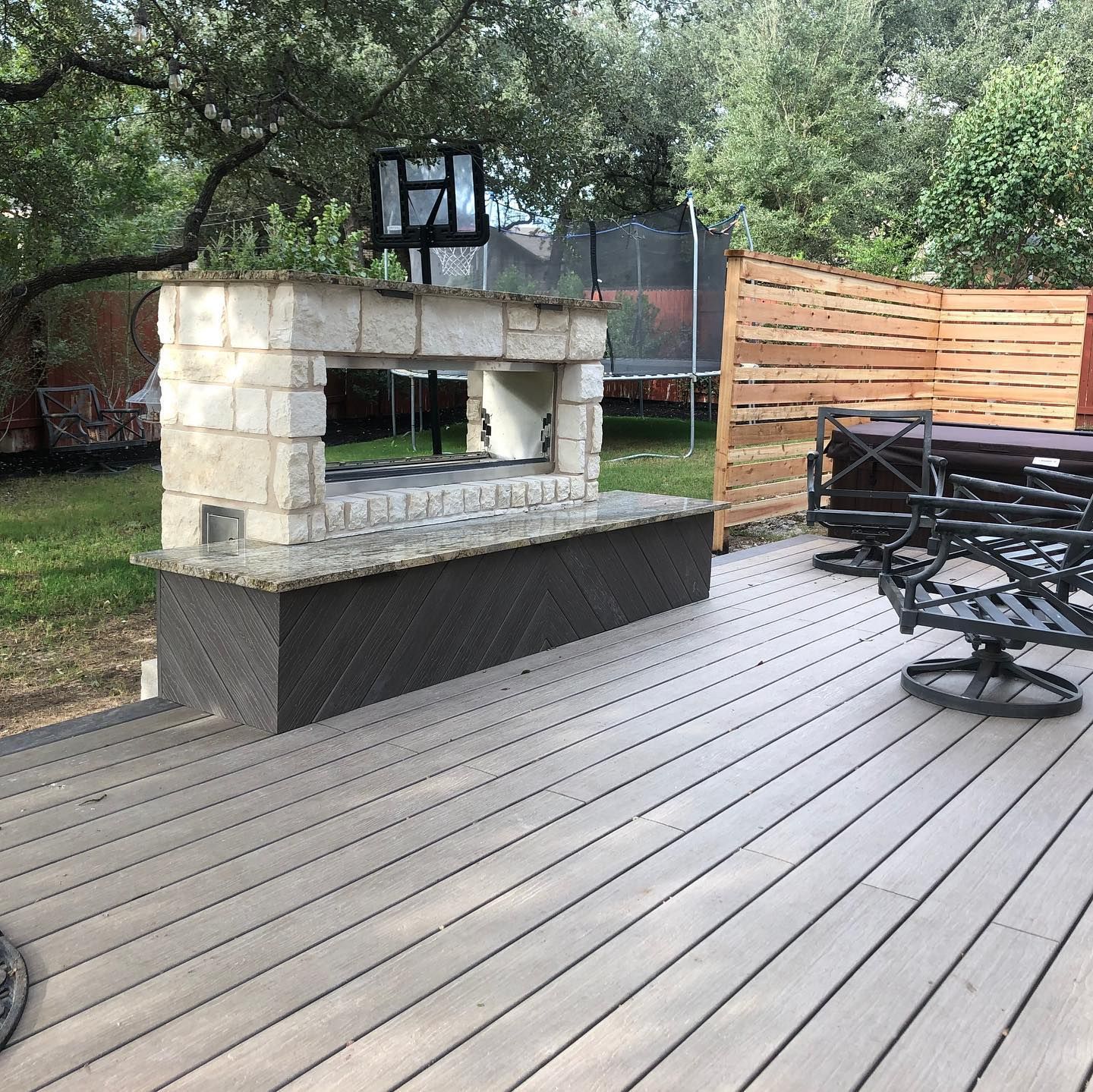 A wooden deck with a brick fireplace in the middle