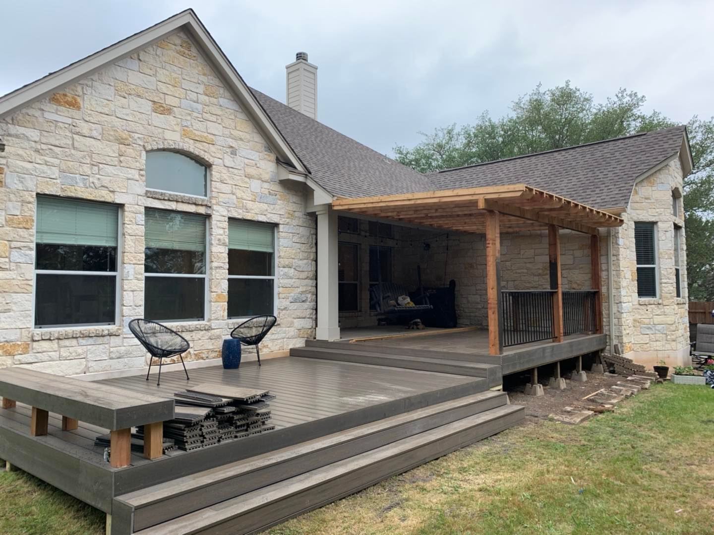 The back of a house with a large deck and a pergola.