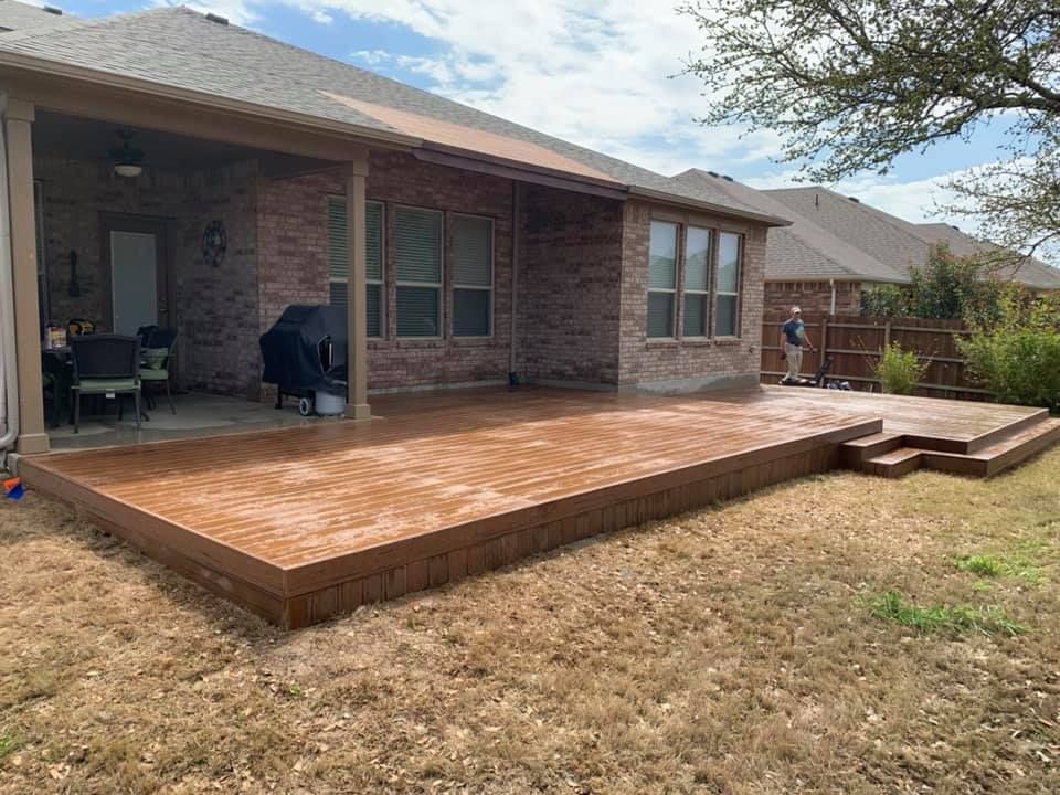There is a concrete deck in the backyard of a house.