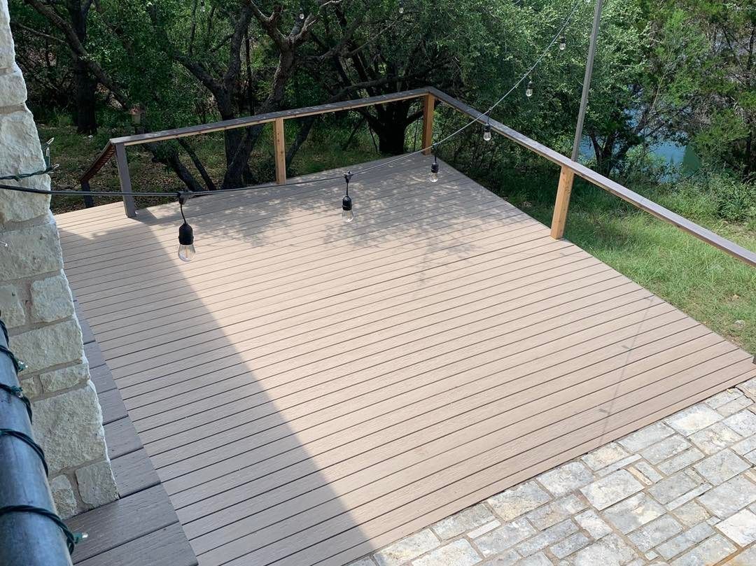A wooden deck with a railing and a view of a river.
