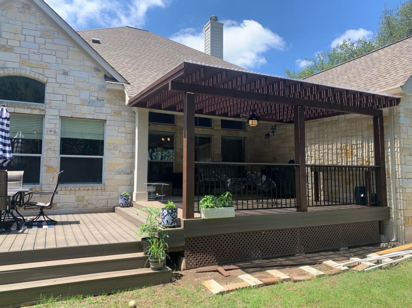 A house with a patio and a pergola in front of it.