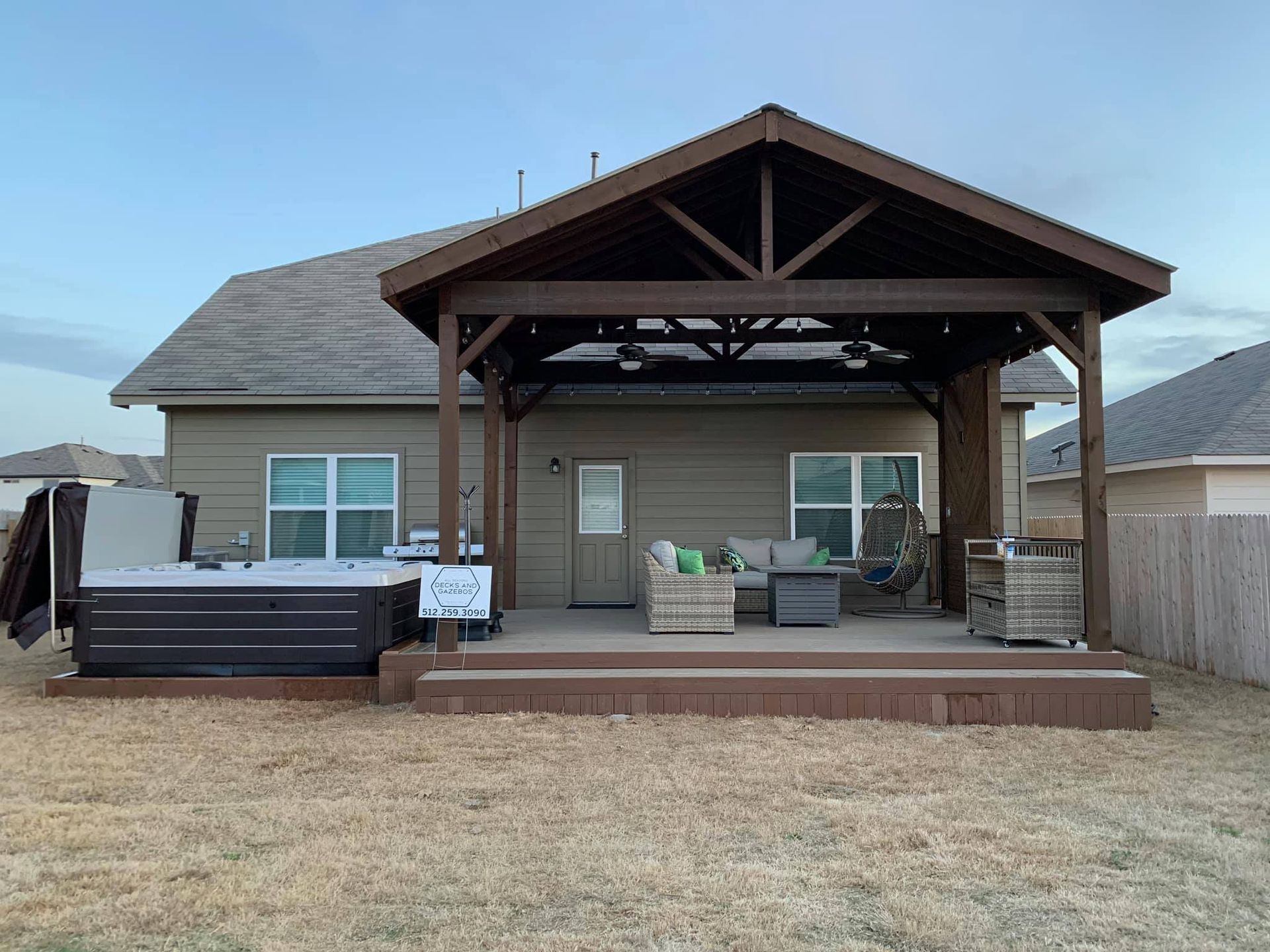 A house with a hot tub and a pergola in the backyard.