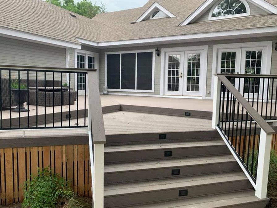 A large house with a deck and stairs leading up to it.